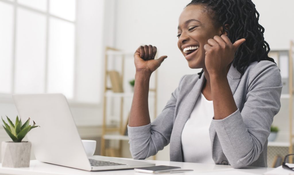 A Female business leader celebrating a success via zoom.